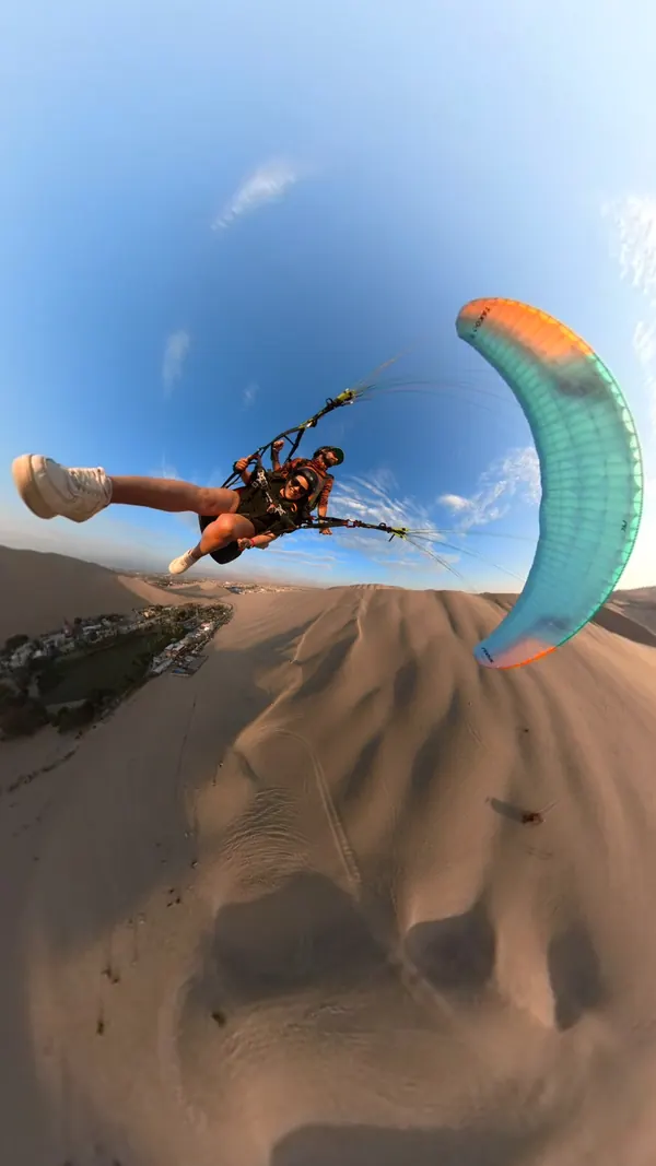 Maniobra de parapente sobre la arena de Huacachina